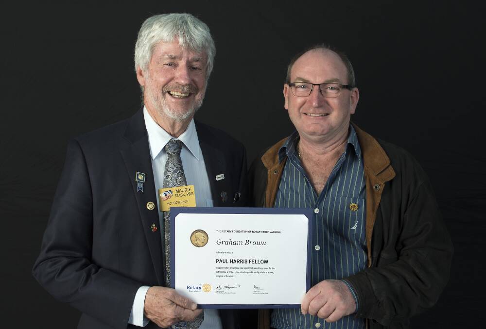 Rotary district governor Maurie Stack presents Graham Brown with his Paul Harris Fellow.