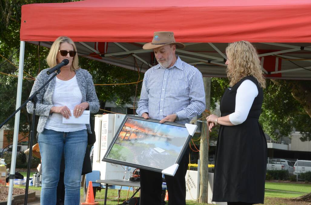 Former Greater Taree City Council executive leader of Corporate Support Laura Black (left) and former personal assistant to the general manager Lineve Dwyer present Ron Posselt with a photographic tribute to the Manning during the community's farewell the council held on June 30.