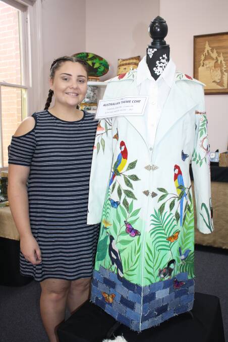Australiana: Demi Fox with her creation, a long, cream coat which is embellished from top to bottom with Australian animals, birds, flowers and scenery.  