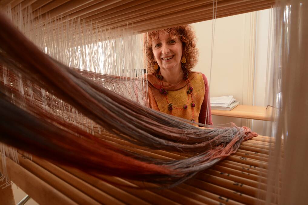 Creation: 'I think weaving is the most human connected craft because it’s so connected with people and their whole lives, and rites of passage through life, from birth to death," said Kaz Madigan, pictured sitting at her 24-shaft loom. Photo: Scott Calvin.