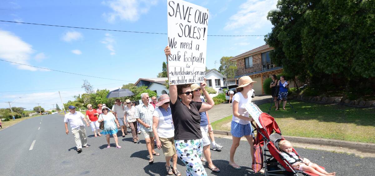 Protest: Old Bar residents walk the main street in protest after funding for a safe and accessible footpath from the CBD to the beach was knocked back for the third time.