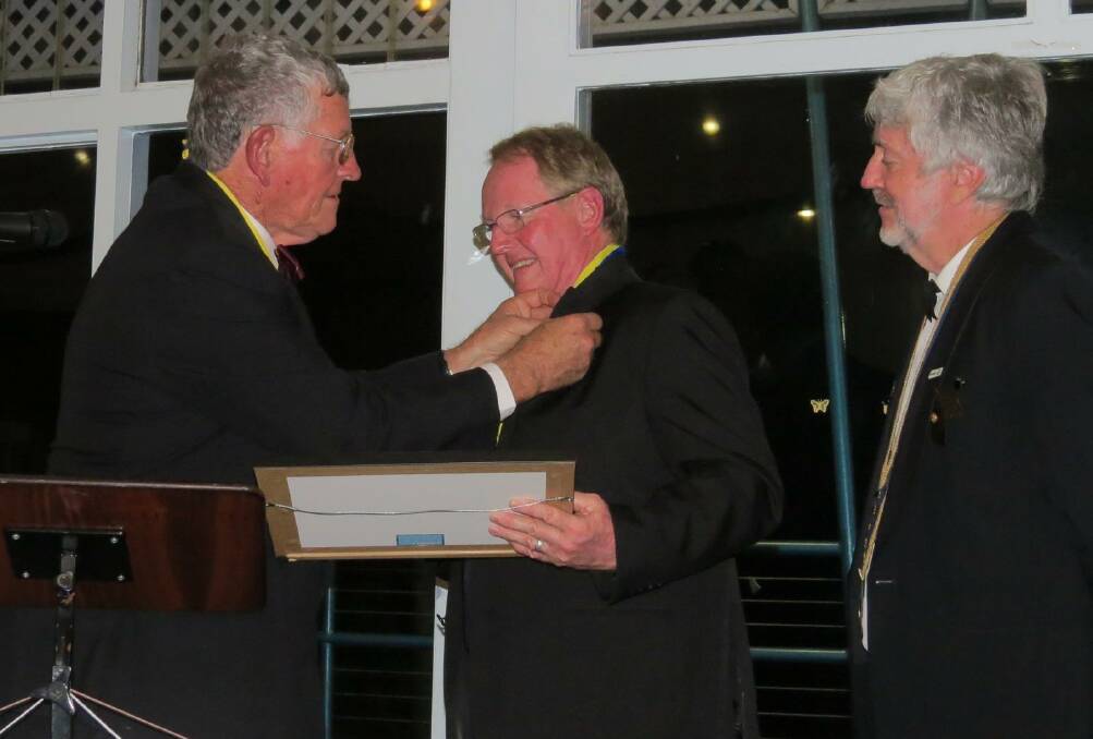 Rotary Club of Taree on Manning president Paul Tollis presents Terence Kitching with his Paul Harris award, while district governor Maurie Stack looks on.