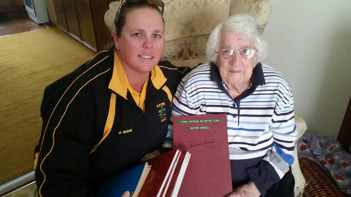 Wendy Bosher receives the club records from Taree Swimming Club life member Gwen Brooks.
