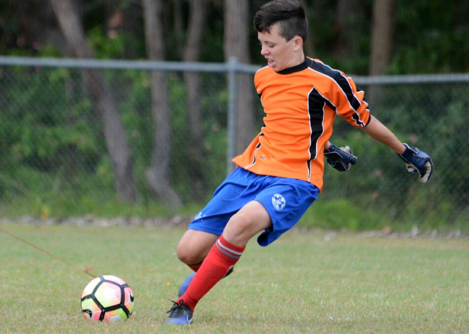 Old Bar under 15 goal keeper Brendan Armstrong clears the ball during the recent clash against Tinonee.