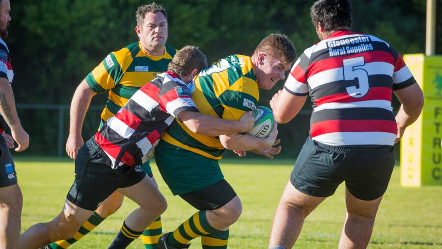 Forster Tuncurry Dolphins prop Ben Manning drives the ball up against Gloucester defenders. The Dolphins meet Wallamba at Nabiac tomorrow. Photo Zac Lyon.