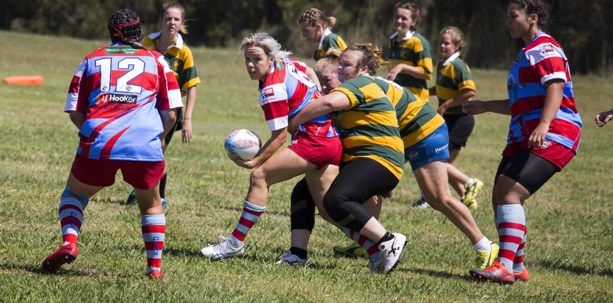 Old Bar captain Annie Taylor offloads to Emily Outred during a match in the Old Bar carnival. Photo Max Lansdowne