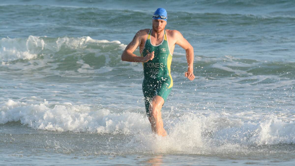 Harry Jones races out of the surf after completing the 500m swim in the Crowdy Bay Triathlon. He went on to win the race convincingly. Photo Scott Calvin.