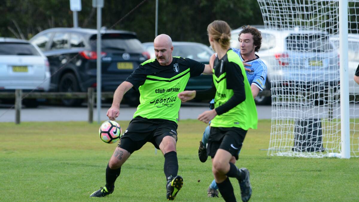 Wallis Lake's Roan Whiteman looks to clear the ball during a Football Mid North Coast with Taree earlier this year. Wallis will meet Port United in the grand final on Saturday at the Port Macquarie Regional Stadium.