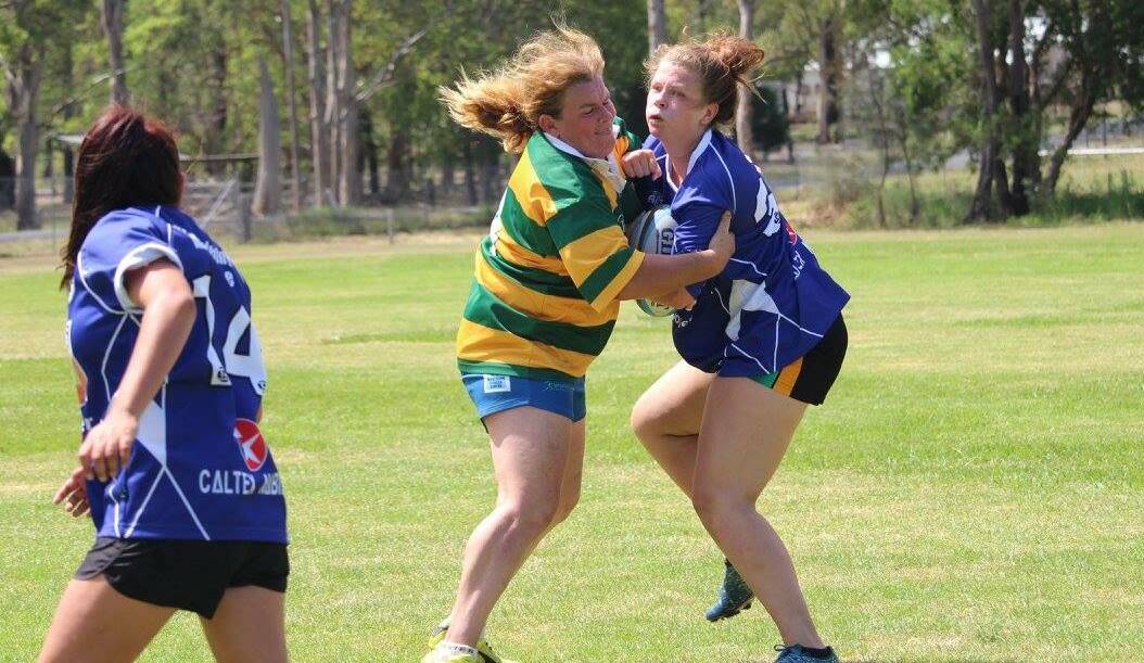 Wendy Wilkins blocks Haley Dunk's progress during a match in the women's rugby sevens gala day played at Nabiac in December. Five sides will contest the inaugural Lower North Coast competition this year.