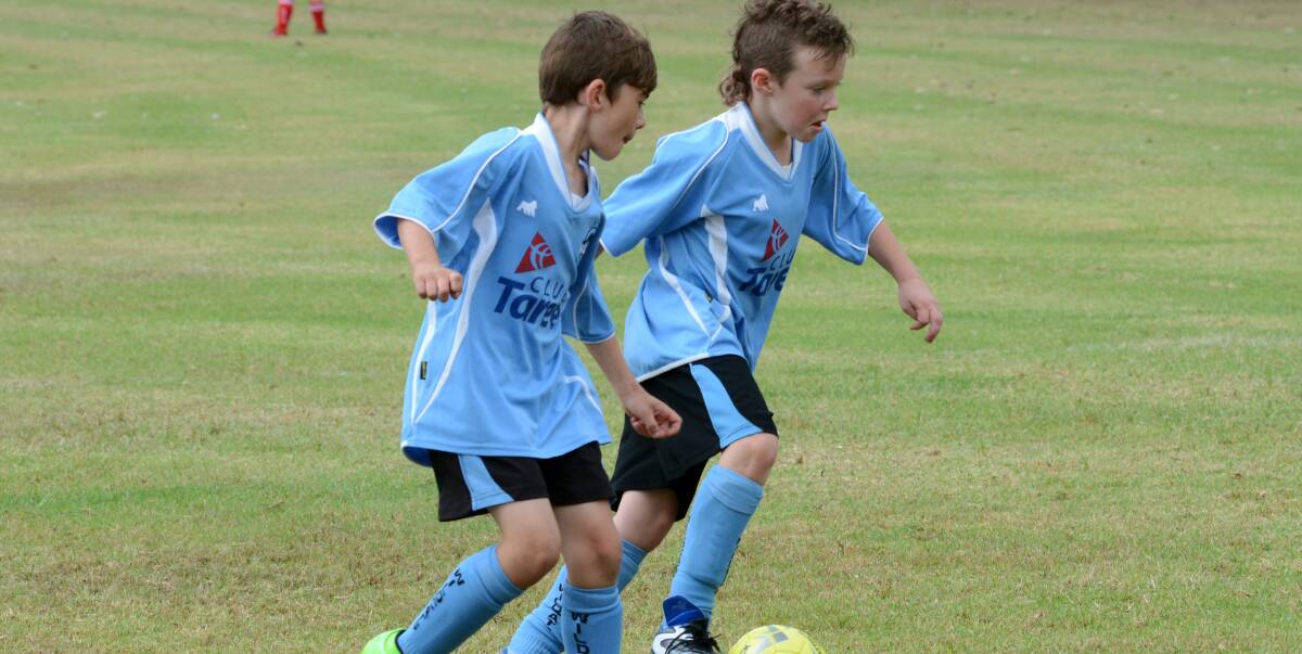 Taree Wildcats teammates Toby Wilson and Riley Webber control play during a match in Football Mid North Coast junior match played at Omaru Park.