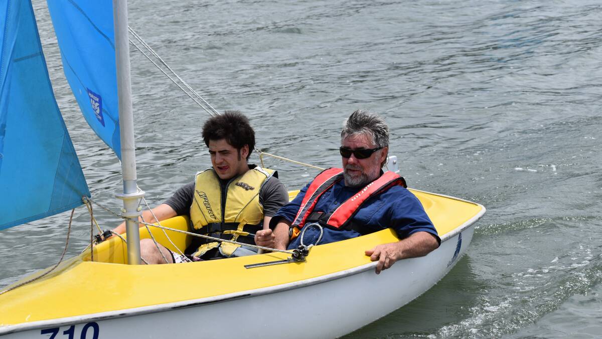 Participant Brock Dawking enjoys the Sailability program with a MidCoast Assist volunteer.