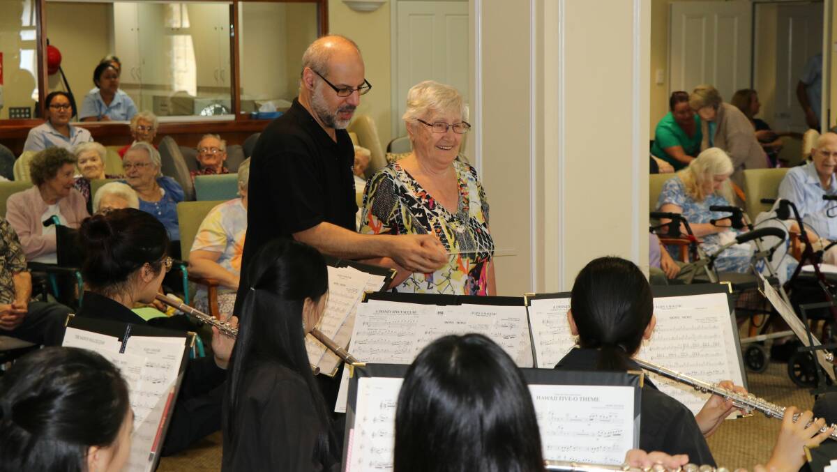 North Sydney Girls High's director of ensembles, Steven Hillinger and Estia Health resident Inge Zielke, conducting the orchestra.