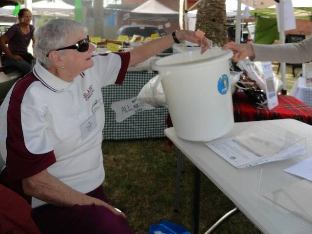 Robyn Shaw drawing the raffle at the Great Lakes and Manning Stroke Recovery Club's  stall at the Farmers Market this month.