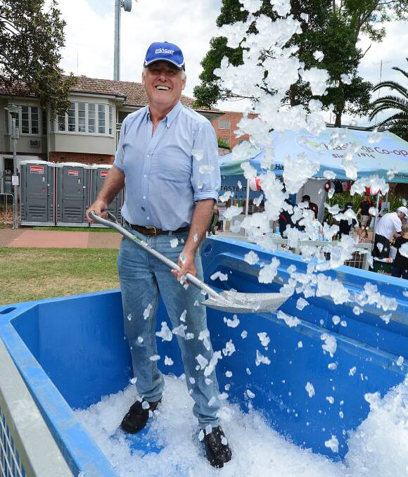 Beat the heat: Peter Caisle shovels ice out to vendors at TasteFest on the Manning. Event organisers Taree Lions Club expected to give out one tonne of ice. Due to the hot conditions three tonne of ice was used. Photo: Scott Calvin. 
