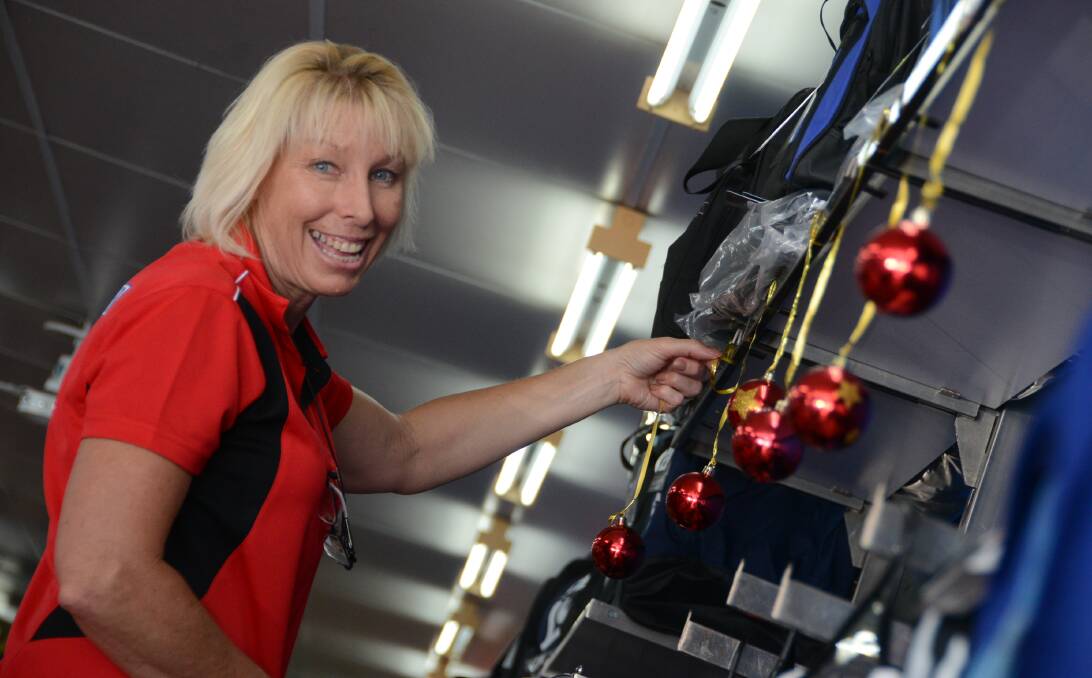 Decking the halls: Narelle Salmon of Bridgeys Sports Power making the finishing touches on the store's Christmas decorations. Bridgeys and other businesses try different gift options to attract Christmas buyers. 