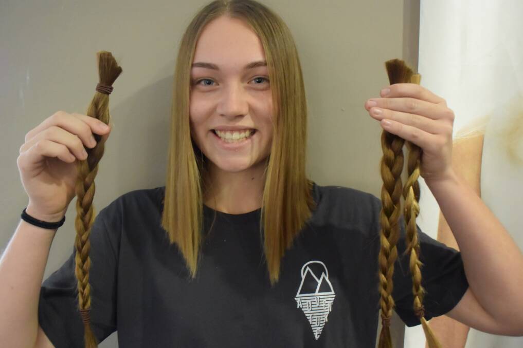Erin Deudney holds the three plaits she will be donating to Wigs for Kids. 