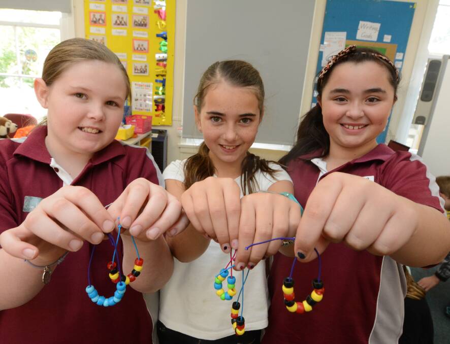 Hayley Rochester, Hannah Dignam and Lorena Jones make beaded necklaces.