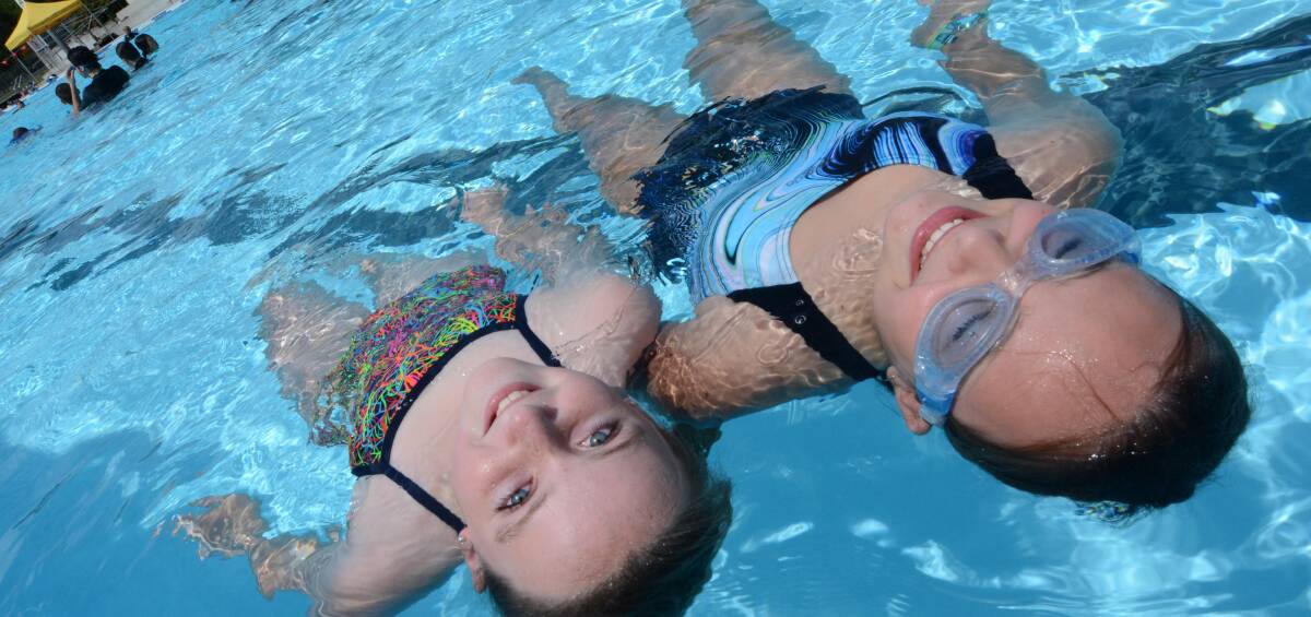 Keeping cool: Year seven students Charlotte Rainger and Maddie Prowse first day at school was spent in the pool at the Manning Aquatic and Leisure Centre. Photo: Scott Calvin. 
