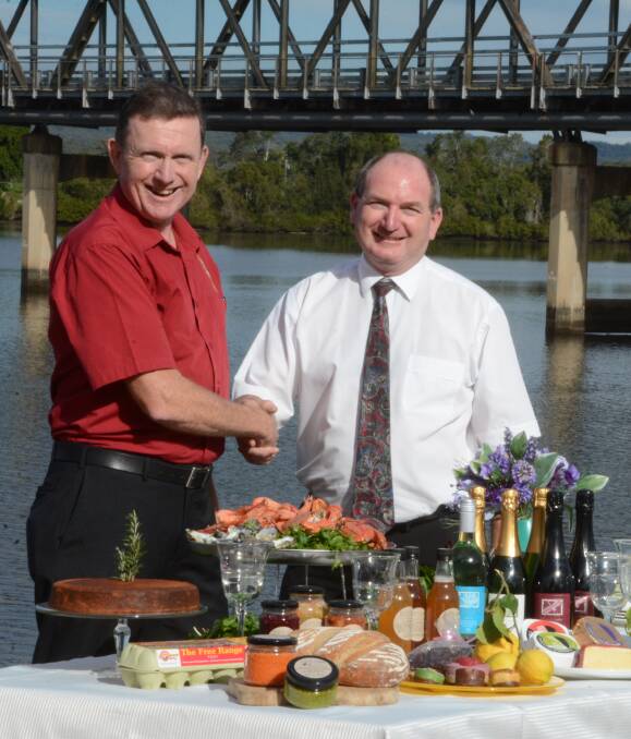 Riverside dining: Lions Club of Taree president Phillip Grisold and GBP accountant Graham Brown shake on GBP's sponsorship of TasteFest. Graham hopes the food festival will become an annual event. Photo: Scott Calvin. 