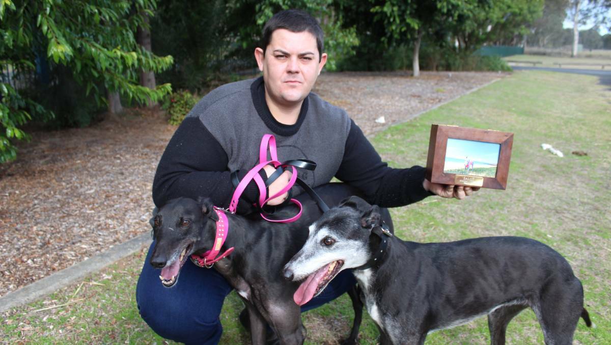 Bradley Barnes with two of his greyhounds, and the ashes of another. He said he always did right by his greyhounds. Picture: Conor Hickey