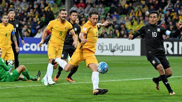 Patience please: Mark Milligan of the Socceroos strikes the ball but fails to break through. Photo: AAP
