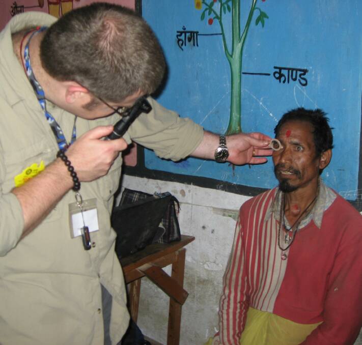 Jason Booth performs a vision test on a Nepalese man during an aid trip. Jason's work has been recognised with his naming as a Member of the Order of Australia.