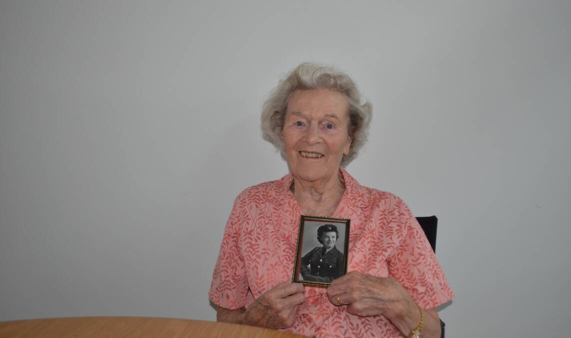 Memories of total war: Kempsey's Margaret Marriott with a photo of herself during her time in the Royal Air Force's intelligence operations. Photo: Lachlan Leeming. 