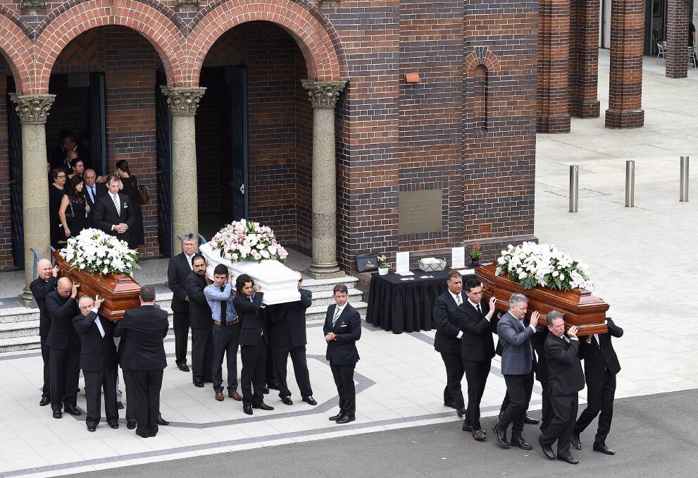 The coffins of Annabelle Falkholt (centre) and her parents Lars and Vivian Falkholt are carried out of St Mary's Catholic Church following their funeral in Concord, Sydney, yesterday. Picture: Kate Geraghty