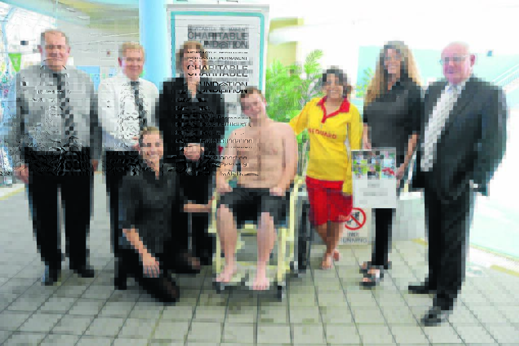 Flashback to 2014: Adam Wilks is able-bodied but happily took a seat in the new water wheelchair at the YMCA Manning Aquatic Leisure Centre in Taree. The chair is a new addition to the facilities and was recently presented to centre for use by Manning Valley residents. In attendance was (from left) Simon Handley, Greg Fuller, Kathrine Silcock,Vanessa Byma, Tracey Croker, Melissa Morgan and Newcastle Permanent Charitable Foundation Chairman, Michael Slater.