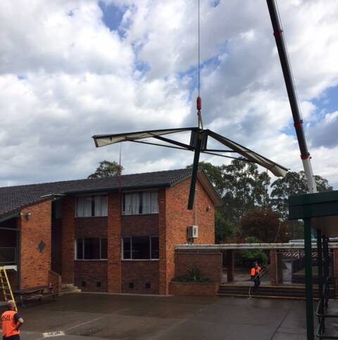 A crane lifted the large umbrella from the junior quad area and moved it to the senior quad area of St Clare's High School in Taree.
