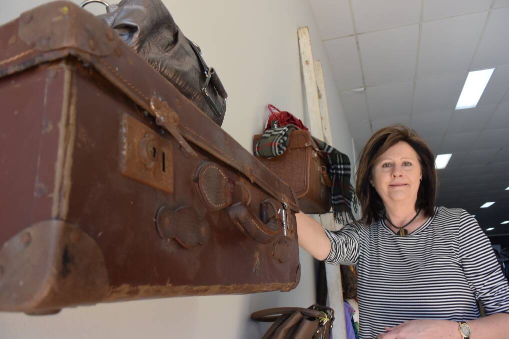 Lifeline Taree store manager Linda Murray uses vintage suitcases to display handbags.