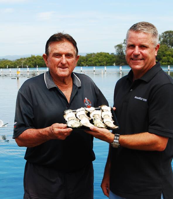 Graham Barclay and Richard Ellery with a sample of the bountiful harvest this year for Sydney Rock Oysters farmers on the mid north coast.