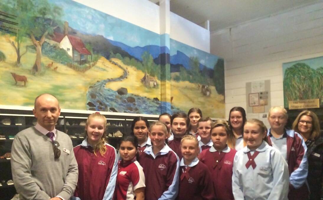 Pastoral scene: Taree Christian School principal David Coleman (far left) with art teacher Catherine Grimwood (far right), and some of the students who participated in painting the mural above them.