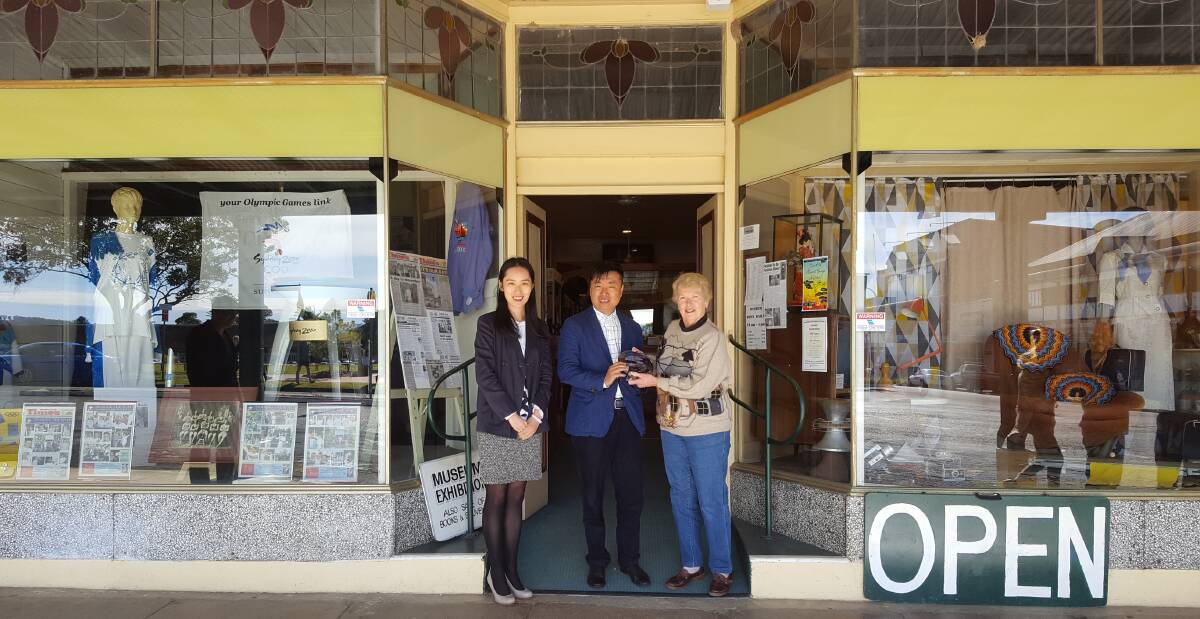 Gift of gratitude: Anna and Mr Li of Shanghai company Aoyaxin Lan Beef presenting Manning Valley Historical Society president Barbara Waters with the specially-made crystal plaque. Photo: supplied.