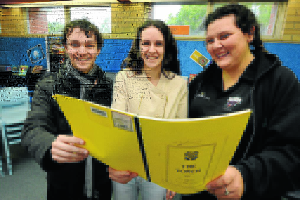 Nick Starr, Lily Minihan and Emma Joyce Croker peruse a 1945 edition of the school magazine The Torch.