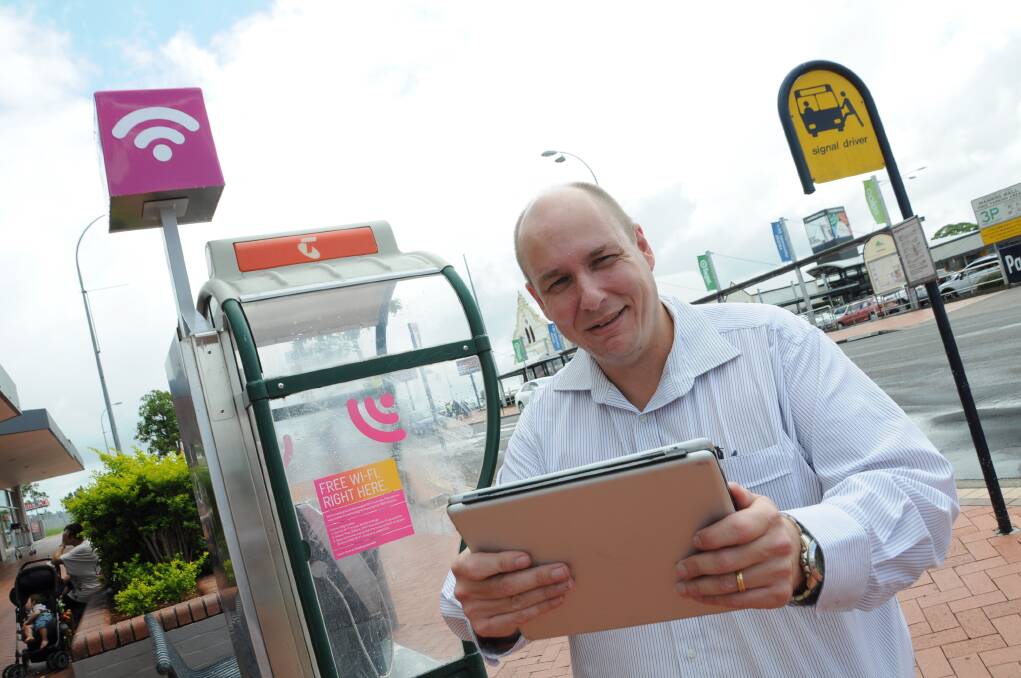 General manager for Hunter and Central Coast areas Chris Cusack demonstrates how easy it is to use the Telstra Wi-fi hotspot outside Taree Central City Centre.