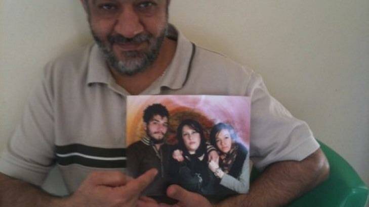 Late Iranian asylum seeker Ali Rahimi, with a photograph of his family. Mr Rahimi died at Villawood detention centre of heart failure in 2012.  Photo: Supplied