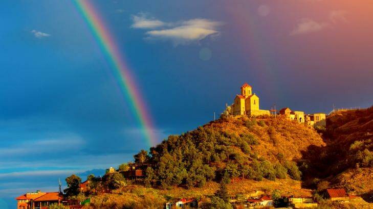 Thabori monastery on a hill with rainbow behind in Tbilisi, Georgia country. Photo: iStock