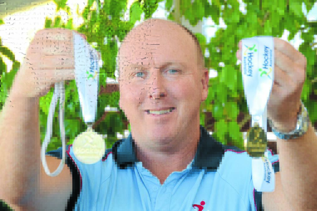 Tony Lewis will be assistant coach for the Australian over 45 women's hockey team next year. He is pictured with the two gold medals he has won after coaching NSW over 45s to successive Australian championship victories.