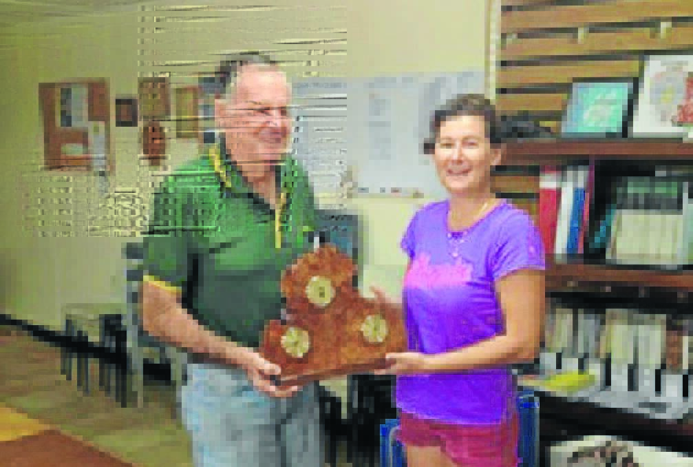 Horrie Beeton from the Manning Great Lakes Woodworkers presents Kathy Bushell from the Taree Aquatic Powerboat Club with the trophy the woodworkers have made for this year's Easter Powerboat Classic.