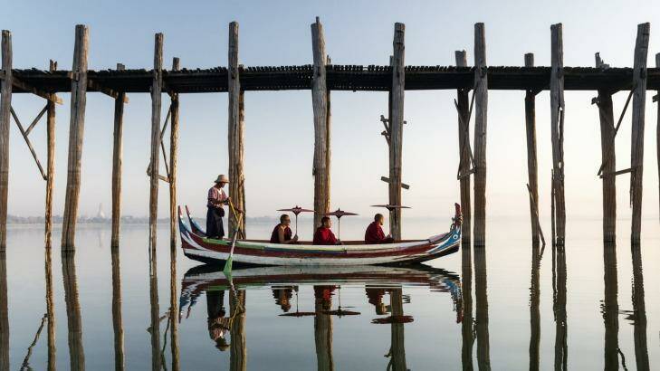 Buddhist monks in boat in front of U Bein bridge. Photo: Martin Puddy