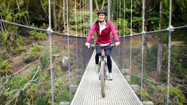 Megan Gale crosses the Maramataha Suspension Bridge on The Timber Trail in New Zealand, beckoning Australians to join her.