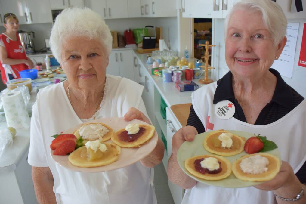 Lyn Macinnis and Genie Williams hold up a delicious plate of pancakes at the Taree Red Cross Club Shrove Tuesday event last year.
