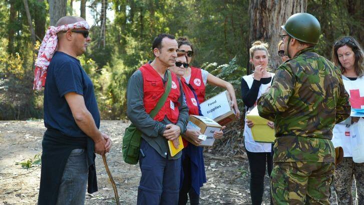 Keep talking. Shane Wilkes, centre, negotiates at a "checkpoint" at a Red Cross hostile environment training camp in Yellingbo, east of Melbourne. Photo: Joe Armao