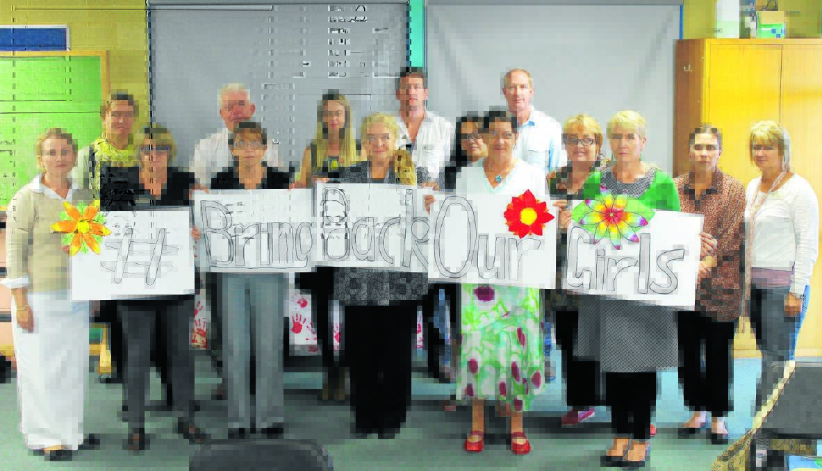 St Joseph's Primary School staff demonstrate to students and our community how to act local and think global by expressing their outrage at the kidnapping of Nigerian school girls. Natasha Brotherton (left) initiated the campaign and received the support of Patricia Paff, Yvonne Nies, Gail Young, Frances Enalaine, Donna Dowsett, Melissa Hunt, principal Mark Mowbray, Rebecca Wilson, Mick Wickham, Adam McCann, Robyn Bielby, Tracey Saunders and Lisa Bourke.