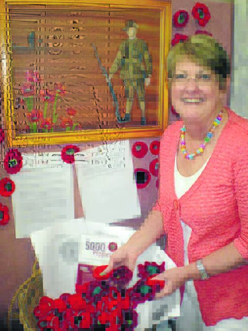 Diane Cubbin adding handmade red poppies to the collection.