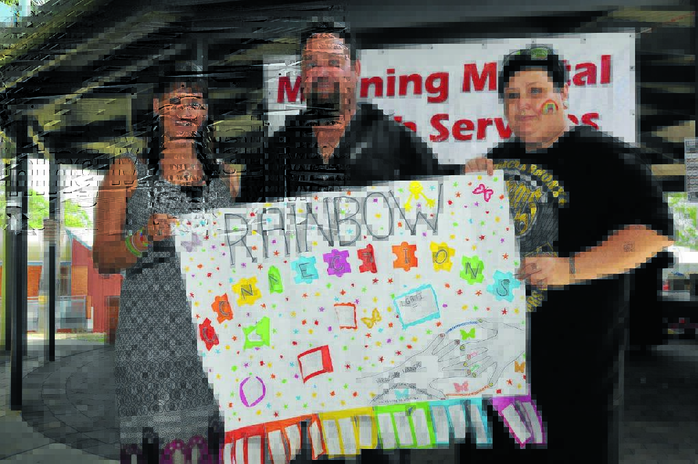 Natacha Van Baars, Chris Carter and Cassy Caddies display a sign from the Lesbian Gay Bisexual Transexual and Inter Sex Community stall.