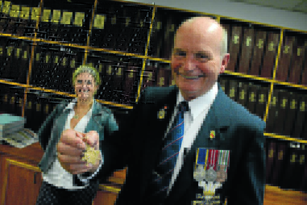 Editor Toni Bell stands behind senior vice-president of Taree RSL Sub-branch and chairman of the Taree 2015 Anzac Day committee Darcy Elbourne. Darcy holds his grandfather's WWI medal, that was found in a Melbourne opportunity shop.