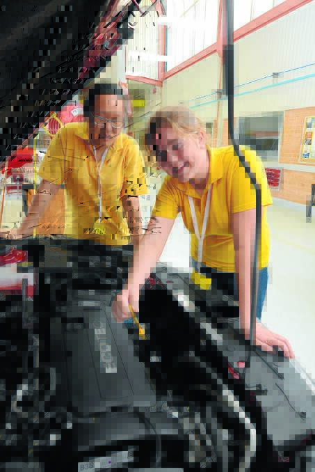 Under the hood: Jessica Adams and Ezabell Kong checking the oil.