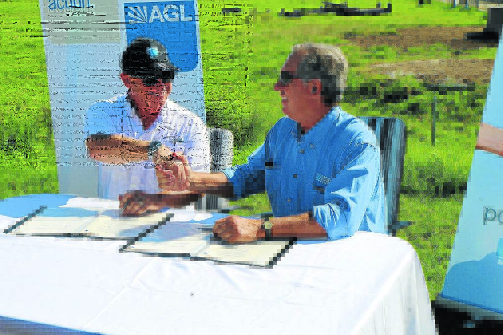 AGL CEO Andy Vesey and Dairy Connect CEO Mike Logan sign the agreement at the Drury Dairy Farm.